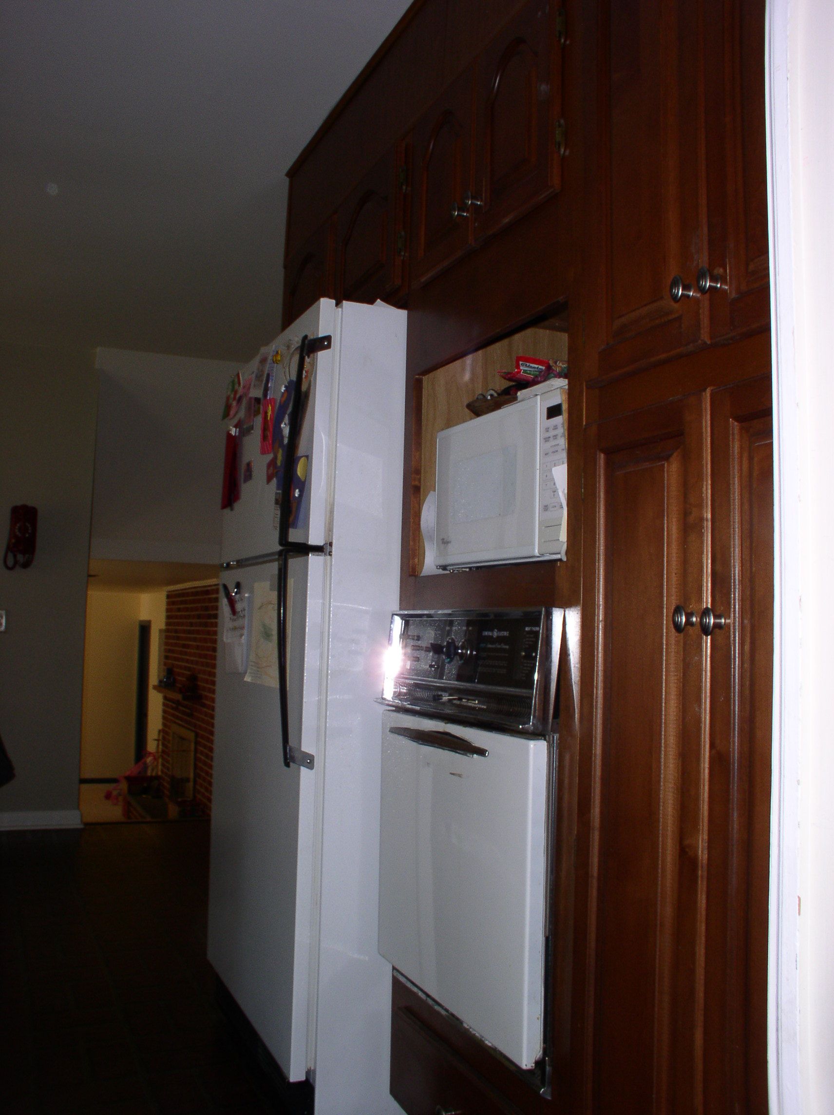 looking at fridge sticking out from wall cabinets