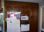 fridge viewed from U-shaped kitchen area.  Notice the doors on both sides of wall cabinet area.